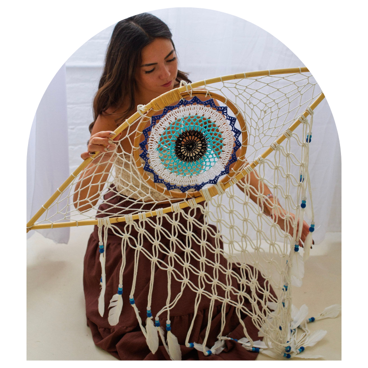 Woman holding a large dreamcatcher with intricate patterns