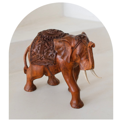Wooden elephant sculpture with intricate carvings on a white background