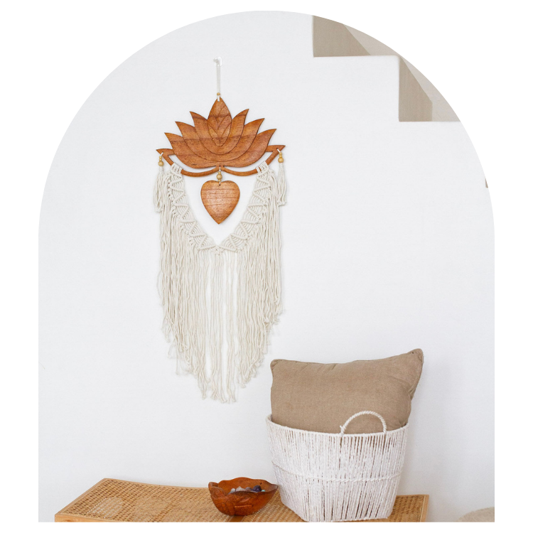 Decorative wall hanging with fringes on a white wall, next to a basket and bowl.